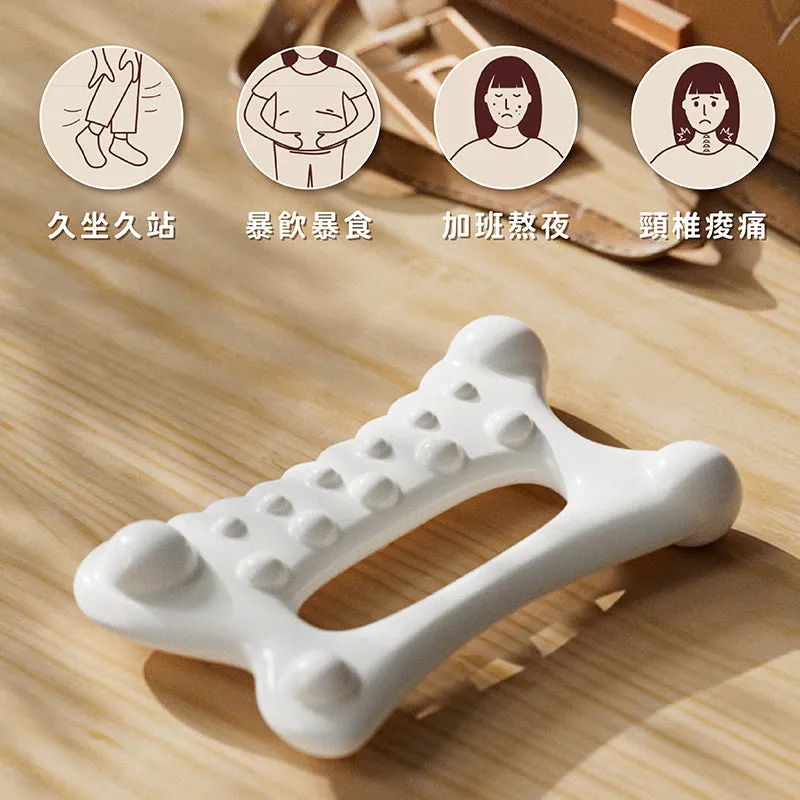 Espandi gua sha tool in cream, bone-shaped, shown on a desk