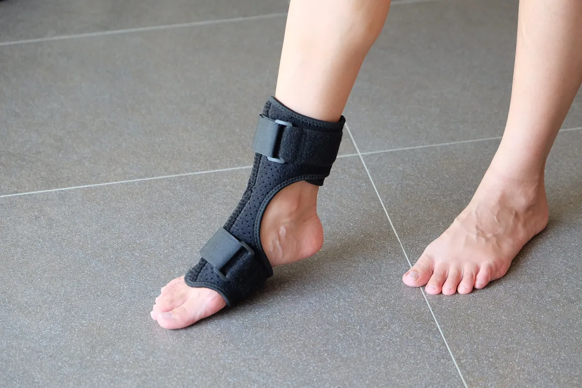 Espandi adjustable ankle brace being worn, seated fitting demo, adjusting the ankle angle