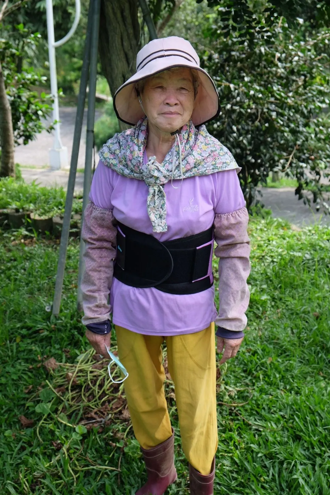 阿嬤戴著帽子站在菜園裡